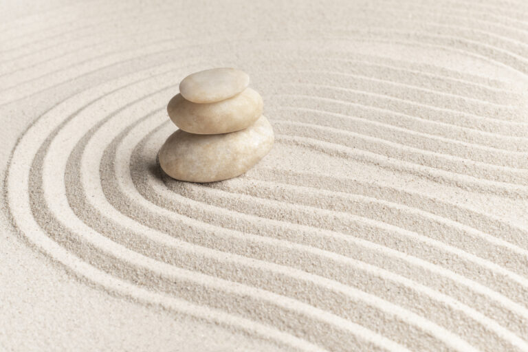 Stacked zen marble stones sand background in mindfulness concept